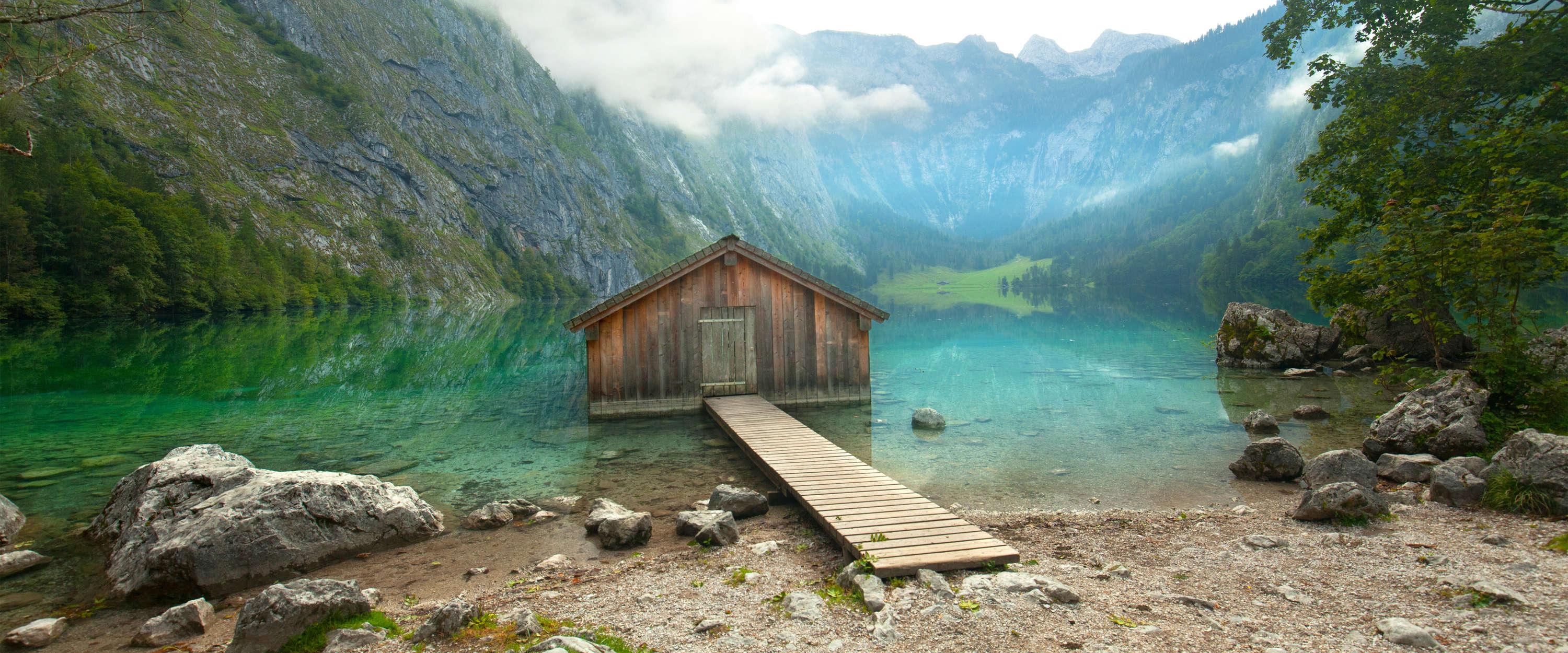             Fototapete Berghütte & See mit Holzsteg & Gipfelpanorama
        