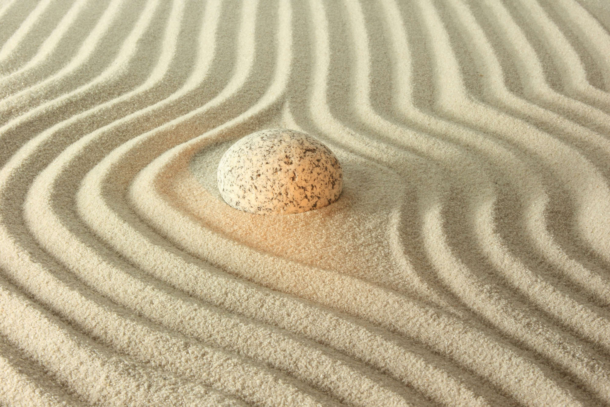             Fototapete leuchtender Stein im Sand – Mattes Glattvlies
        