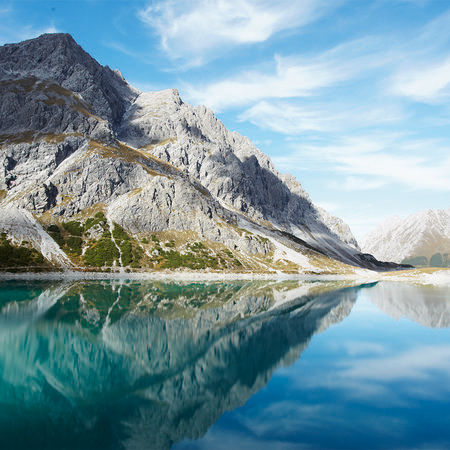 Bergsee klar – Fototapete mit natürlichem Bergpanorama
