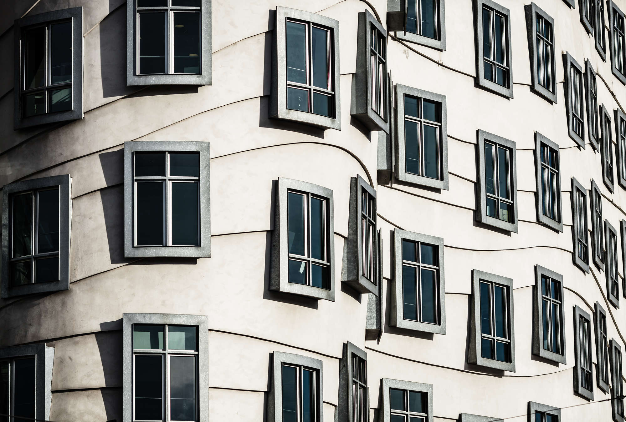             Fototapeten Tanzendendes Haus – Moderne Fenster-Architektur
        