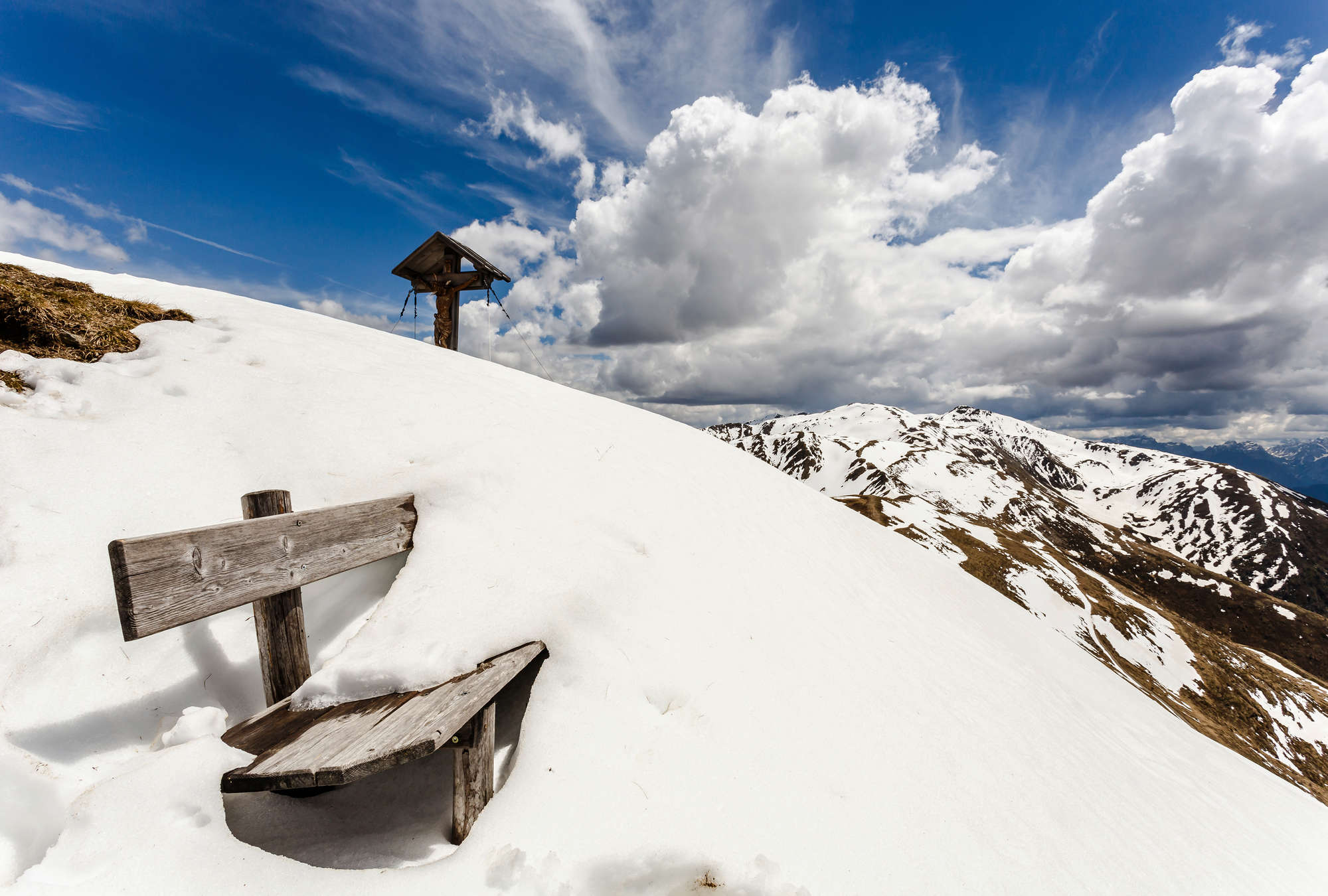            Fototapete Winterlandschaft in den Bergen – Verschneite Bank
        