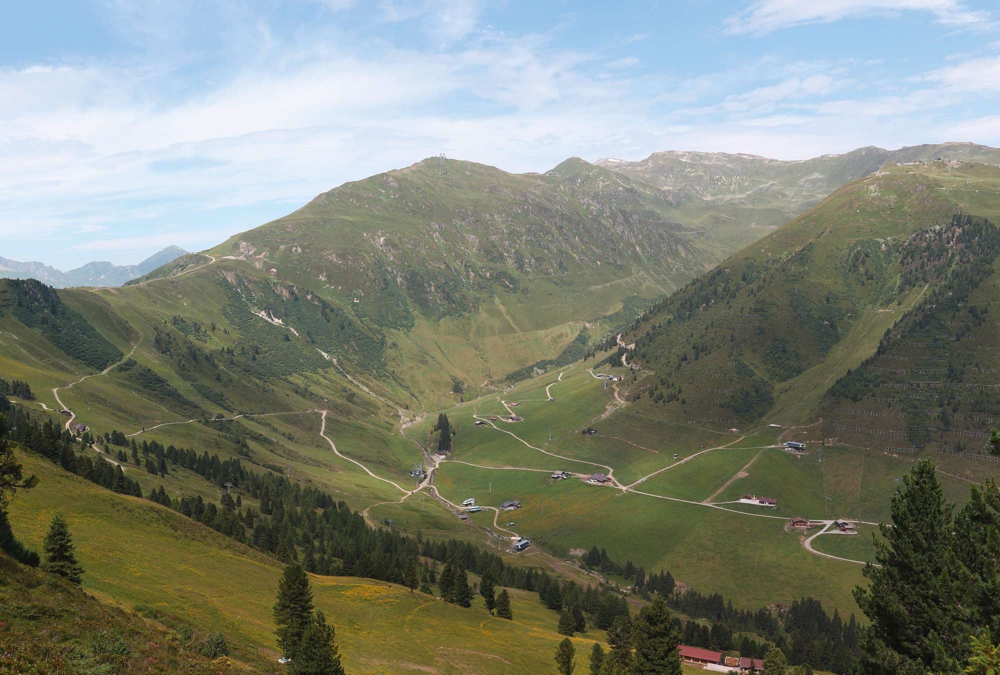             Fototapeten Talblick auf grüne Wiesen in den Alpen
        