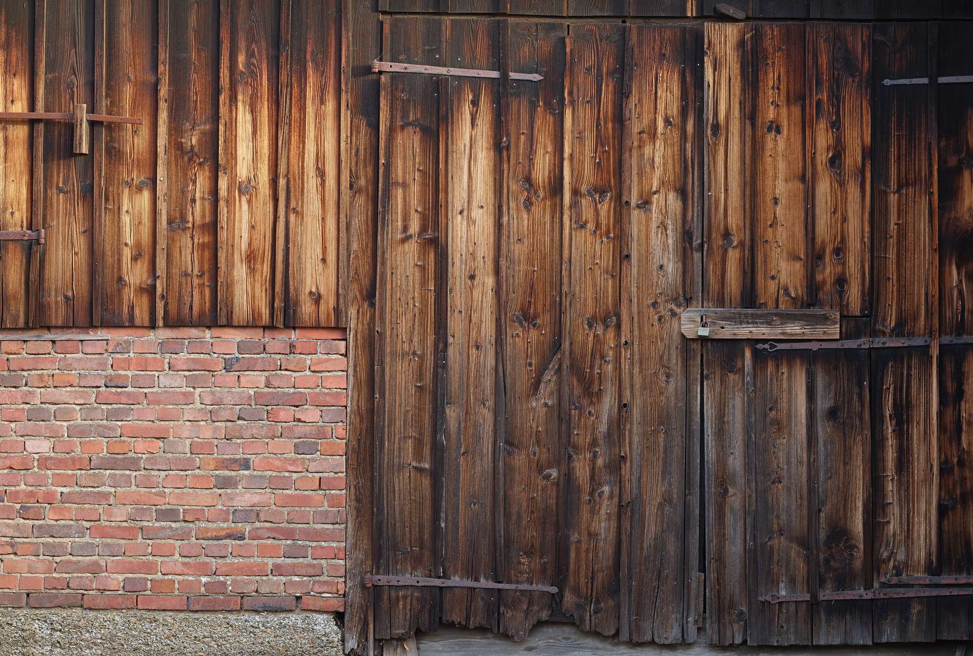            Fototapete rote Ziegelmauer mit Holzplanken und Scheunentor
        