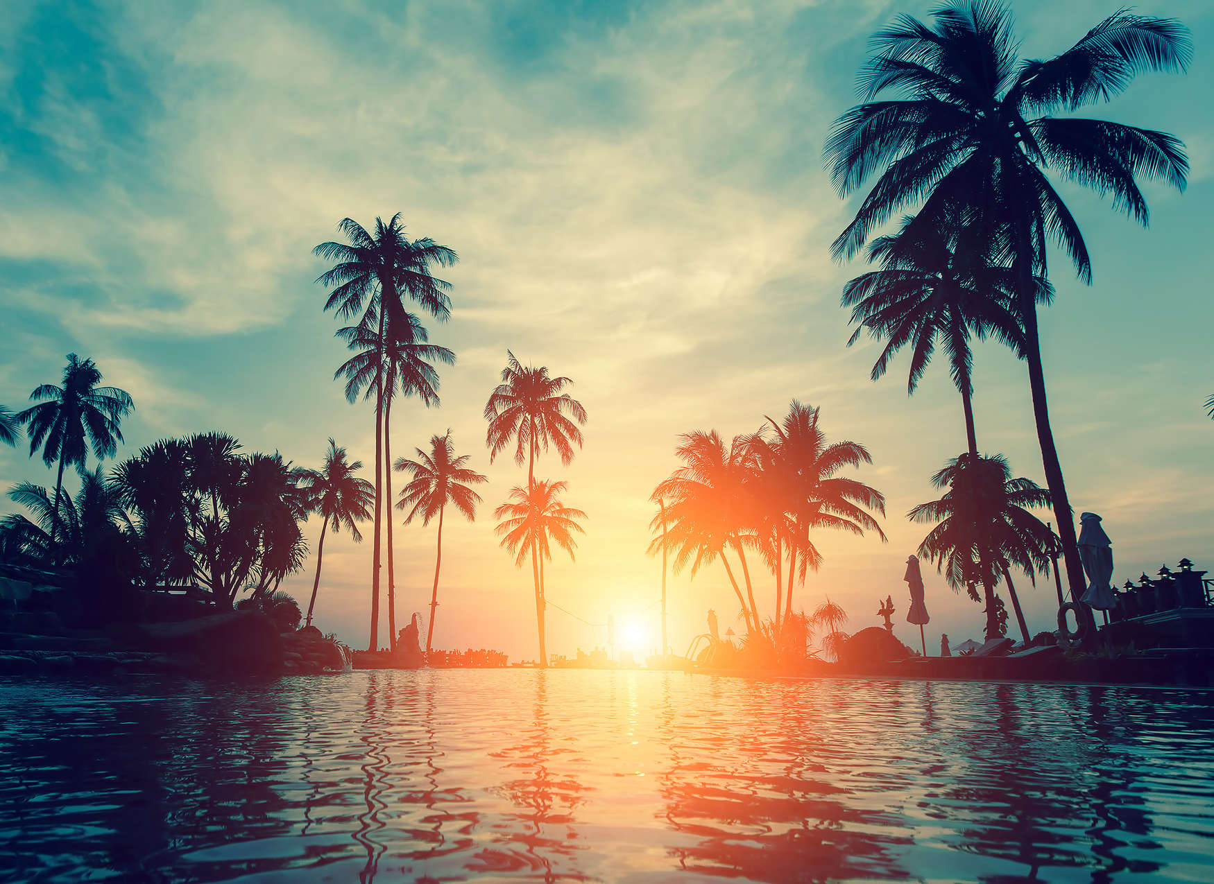             Fototapete mit Palmen am Wasser im Sonnenuntergang – Blau, Orange, Schwarz
        