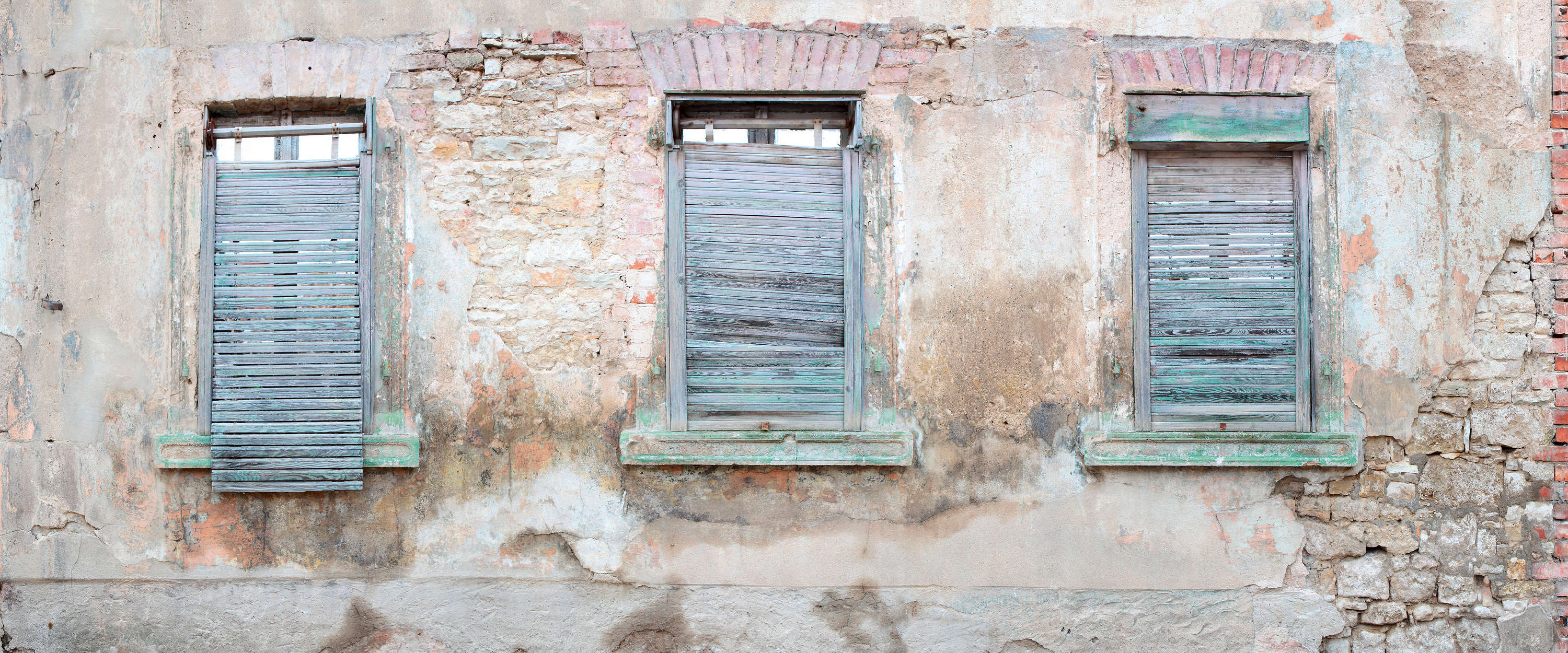             Fototapete Ziegelmauer mit rustikalen Fensterläden und Rundbögen
        
