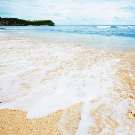 Fototapete Sandstrand auf Bali mit schäumenden Wellen
