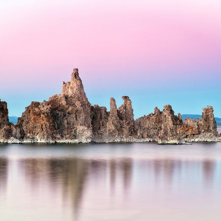         Fototapete Felsen im spiegelndem Wasser mit rosa Himmel
    
